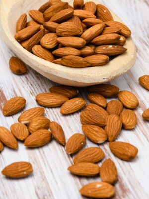 Almonds in a wooden spoon on a wooden background. Amandes Naturelles - Croquantes et Savoureuses